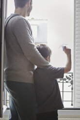 Junge wirft Papierflugzeug aus dem Fenster - CUF36157