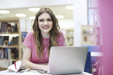 Junge Frau benutzt Laptop in der Bibliothek - CUF36167