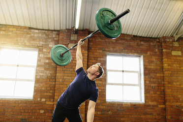 Man lifting barbell with one hand - CUF36176