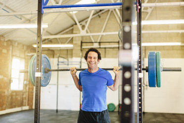 Mann hebt Langhantel im Fitnessstudio - CUF36181