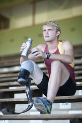 Sprinter sitting with prosthetic leg on - CUF36245
