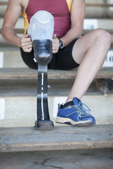 Sprinterin bereitet sich vor und zieht ihre Beinprothese an - CUF36249