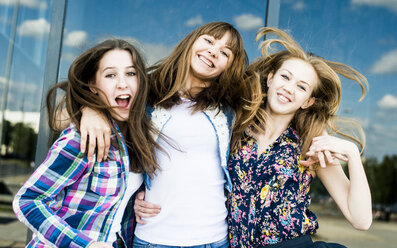 Drei junge Frauen schütteln ihre Haare in einer Reihe - CUF36268