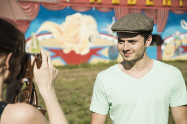 Junges Paar beim Fotografieren mit einer Spiegelreflexkamera auf einem Rummelplatz - CUF36283
