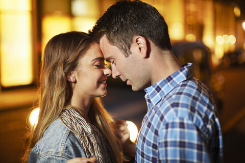 Romantisches Paar von Angesicht zu Angesicht auf einer nächtlichen Straße, lizenzfreies Stockfoto