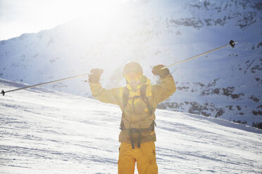 Mittlerer erwachsener männlicher Skifahrer, der seine Skistöcke hochhält, Österreich - CUF36321