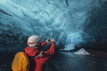Mann fotografiert Eishöhle mit Smartphone, Vatnajokull-Gletscher, Vatnajokull-Nationalpark, Island - CUF36323
