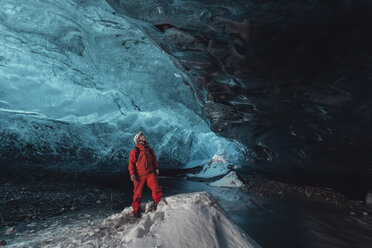 Mann, der in einer Eishöhle nach oben blickt, Vatnajokull-Gletscher, Vatnajokull-Nationalpark, Island - CUF36324