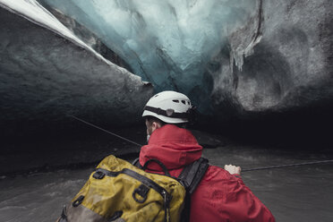 Mann überquert Fluss mit Seil in Eishöhle, Vatnajokull-Gletscher, Vatnajokull-Nationalpark, Island - CUF36326