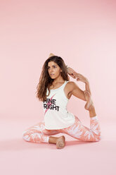 Studioaufnahme einer jungen Frau in Yoga-Position kniend mit Händen hinter dem Rücken - CUF36332