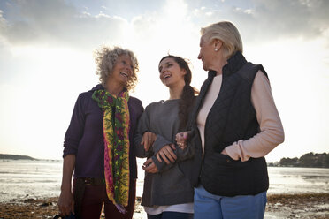 Weibliche Familienmitglieder unterhalten sich am Strand - CUF36339
