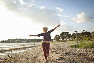 Reife Frau genießt den Strand - CUF36355