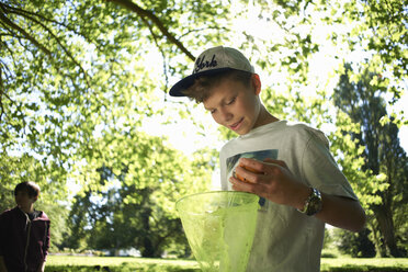 Teenage boy holding fishing net - CUF36378