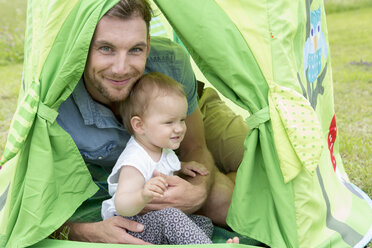 Father with baby daughter in tent - CUF36401