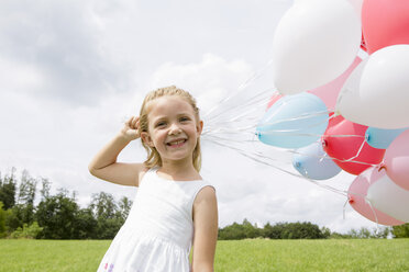 Girl holding a bunch of balloons - CUF36411