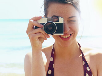 Junge Frau mit Kamera am Strand - CUF36454