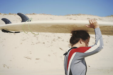 Surfer trägt Surfbrett auf dem Kopf am Strand, Lacanau, Frankreich - CUF36495