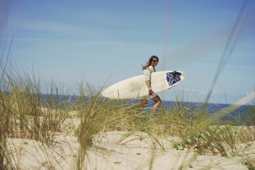 Woman with surfboard on beach, Lacanau, France - CUF36502