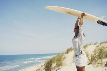 Frau mit Surfbrett am Strand, Lacanau, Frankreich - CUF36504