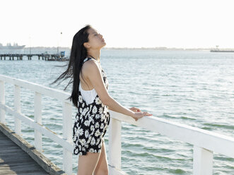 Young woman gazing from pier, Port Melbourne, Melbourne, Victoria, Australia - CUF36516