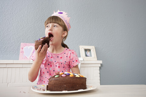 Mädchen isst ihren Geburtstagskuchen, lizenzfreies Stockfoto