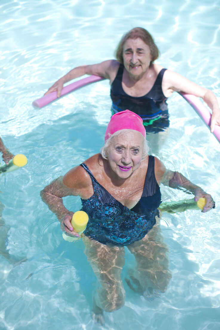 Portrait of senior women doing exercise in swimming pool stock photo