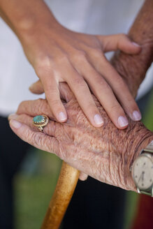 Nahaufnahme der Hand eines Pflegehelfers, der eine ältere Frau beruhigt - CUF36599