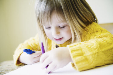 Young girl at kitchen table coloring in with felt pens - CUF36646