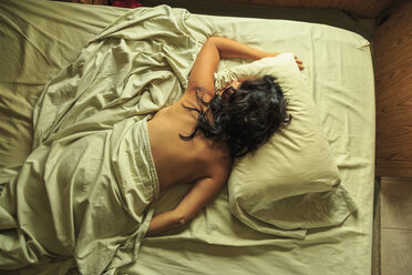Blick von oben auf eine reife Frau, die mit dem Gesicht nach unten auf dem Bett schläft - ISF14432
