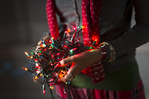 Nahaufnahme einer jungen Frau, die ein Knäuel von Weihnachtslichtern hält - ISF14449