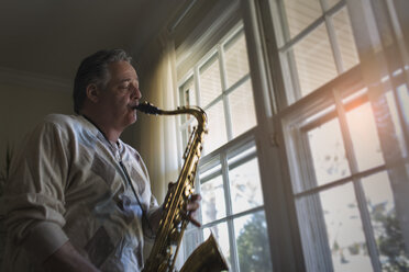 Älterer Mann spielt zu Hause Saxophon - ISF14491