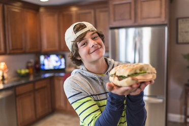 Jugendlicher in der Küche mit Sandwich in der Hand - ISF14531