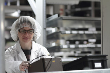 Female scientist monitoring test in laser laboratory - CUF36703