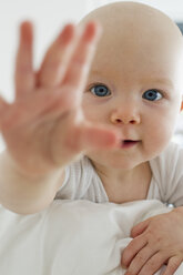 Portrait of baby girl reaching towards camera - CUF36748
