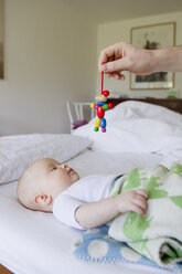 Father holding wooden toy for baby daughter - CUF36786