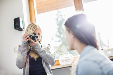 Teenage girl photographing friend with camera - CUF36796