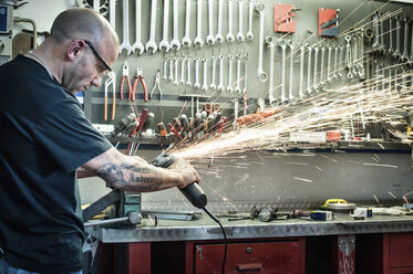 Männlicher Mechaniker beim Schleifen von Metall in einer Werkstatt - CUF36848