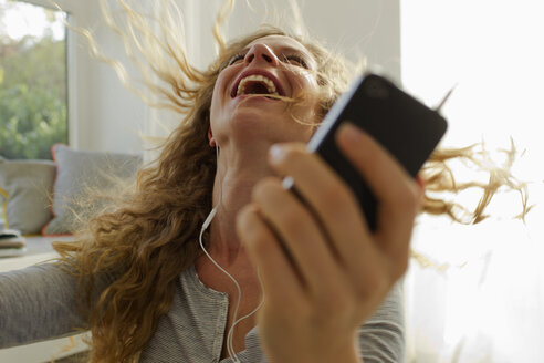 Woman dancing to music on smartphone - CUF36886