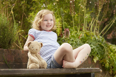 Mädchen auf Gartenstuhl mit Teddybär und Sternaufklebern auf den Beinen - CUF36906