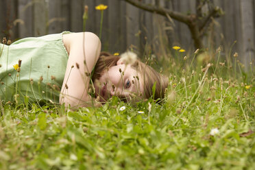 Mädchen liegt auf Gartengras und träumt - CUF36912