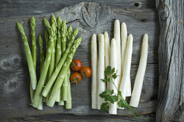 Grüner und weißer Spargel, Petersilie, Tomaten und gemischte Pfefferkörner auf Holz - ASF06188