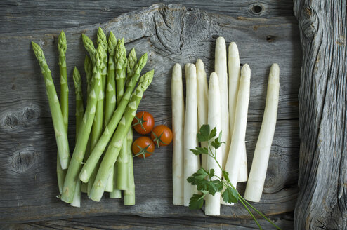 Green and white asparagus, parsley, tomatoes and mixed peppercorns on wood - ASF06188