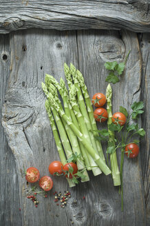 Grüner Spargel, Petersilie, Tomaten und gemischte Pfefferkörner auf Holz - ASF06189