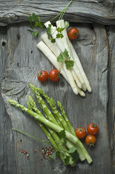 Grüner und weißer Spargel, Petersilie, Tomaten und gemischte Pfefferkörner auf Holz - ASF06190