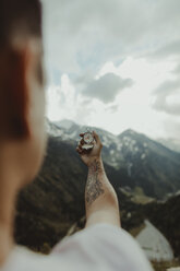 Andorra, back view of tattooed man holding compass - OCAF00332