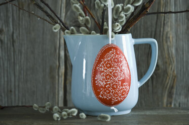 Hand-painted Easter egg hanging in front of light blue jar - ASF06198