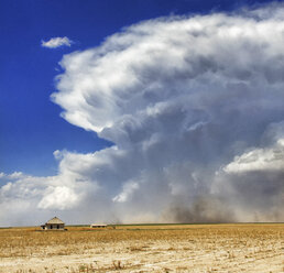 Eine kräftige Superzelle mit starkem Abwind an der Rückseite, die sich auf diesem Bild von links nach rechts bewegt, wirbelt Staub und Böen in der Nähe eines verlassenen Bauernhauses auf, Sheridan Lake, Colorado, USA - CUF36956