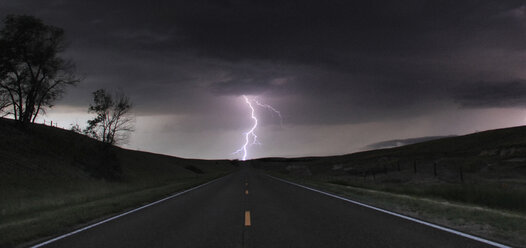 A single cloud-to-ground bolt lands at the end of a rural road, Lexington, Nebraska, USA - CUF36958