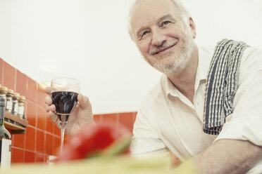 Senior man holding red wine, portrait - CUF37017