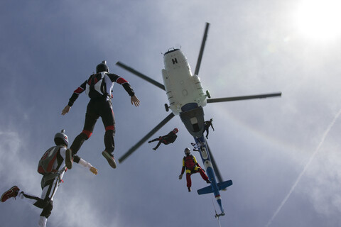 Low angle view of helicopter and six skydivers free falling, Siofok, Somogy, Hungary stock photo